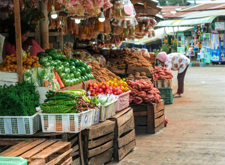 market stalls displaying different types of fruits and vegetables