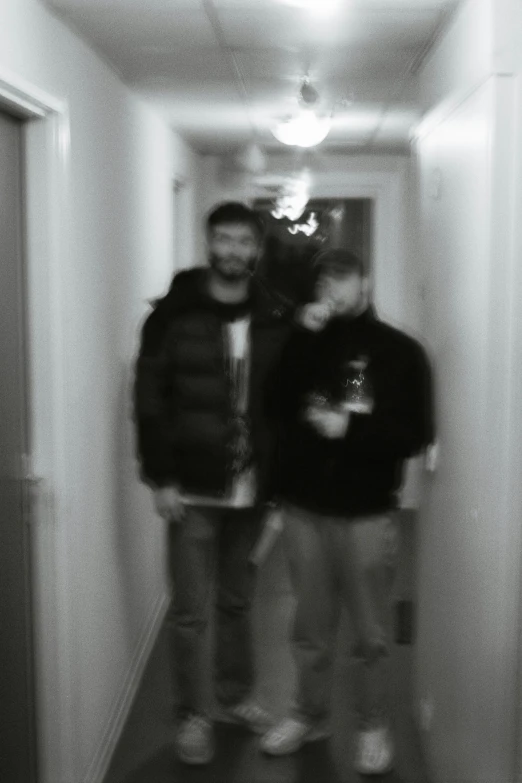 two people are standing in a dark hallway