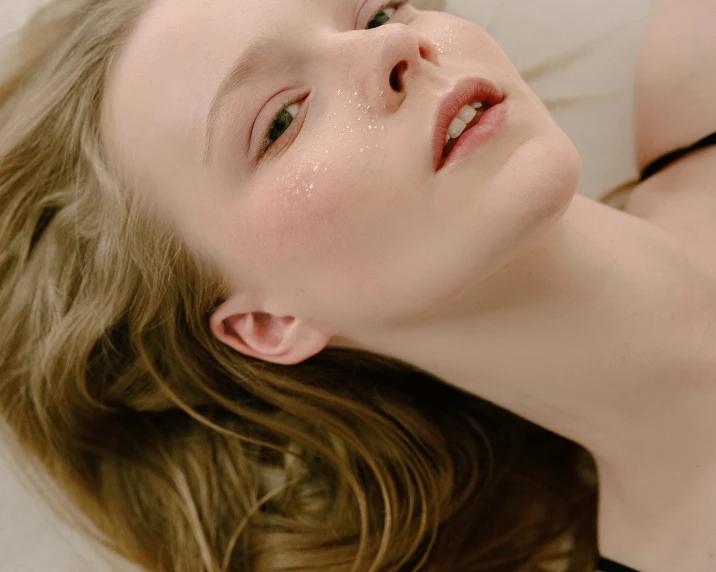 a woman laying on a towel brushing her teeth