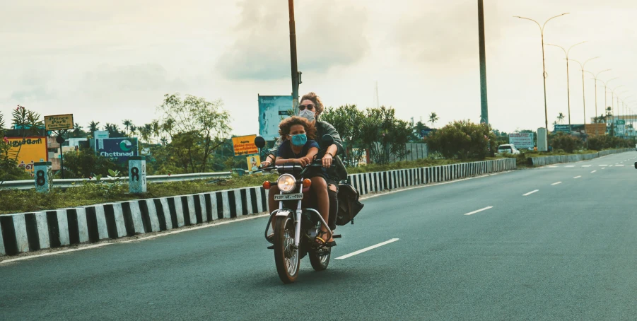 two people riding motorcycles down a freeway