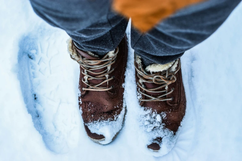 person in brown winter boots with brown and white shoes