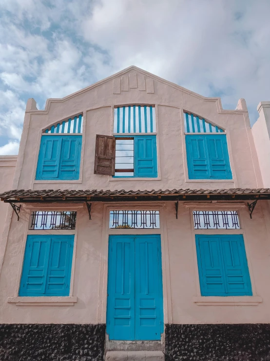 a building with blue shutters on the front and sides