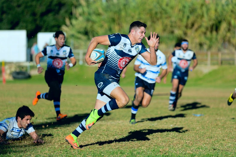 two rugby teams running on the field during the game