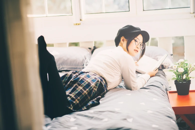 a person laying on a bed wearing glasses and hat