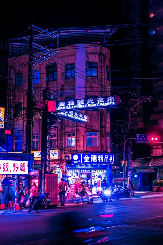 a group of people standing on the side of the street at night