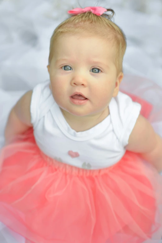 a little baby with a bright orange tutu skirt