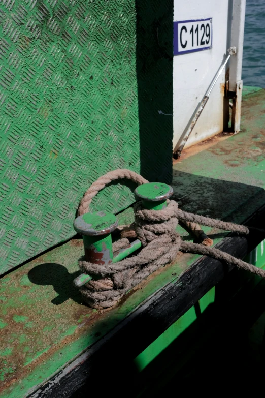 rope tied to the edge of a green boat