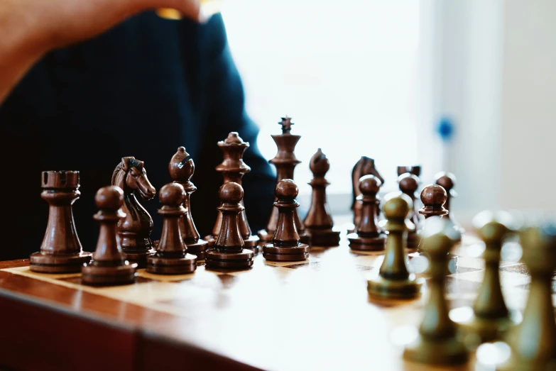 a man with his hand on a chess board