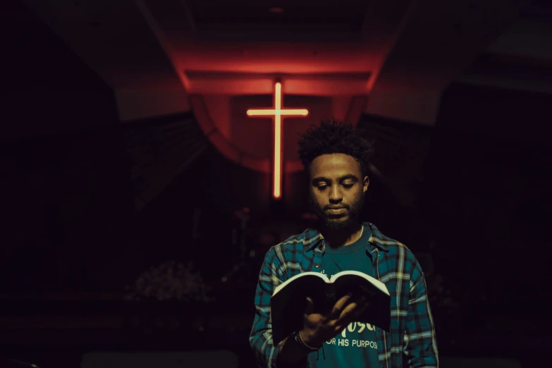 man standing in front of cross wearing plaid shirt