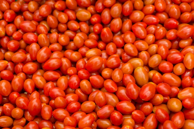 a group of tomatos arranged together in a bowl