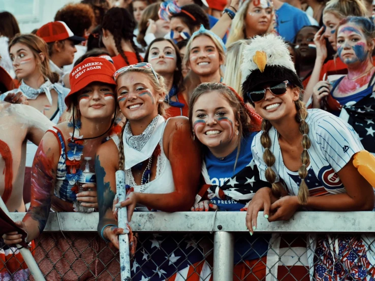 many people are in a fence and some have painted faces