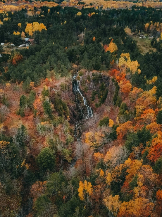 an aerial view of a waterfall in a wooded area