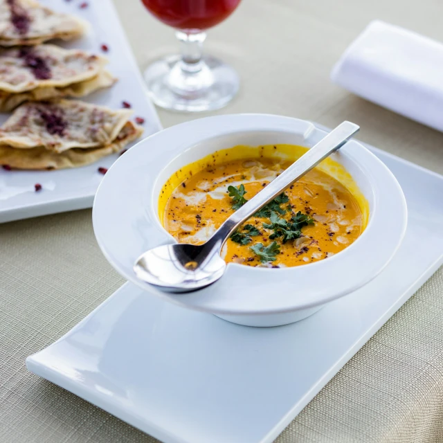 soup with soup spoon and plate on place mat