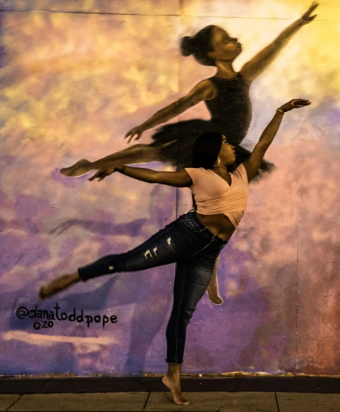 two young people are doing dance poses against a painted wall