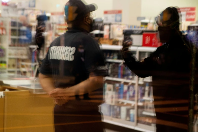 two men are talking while standing in the aisle of a store