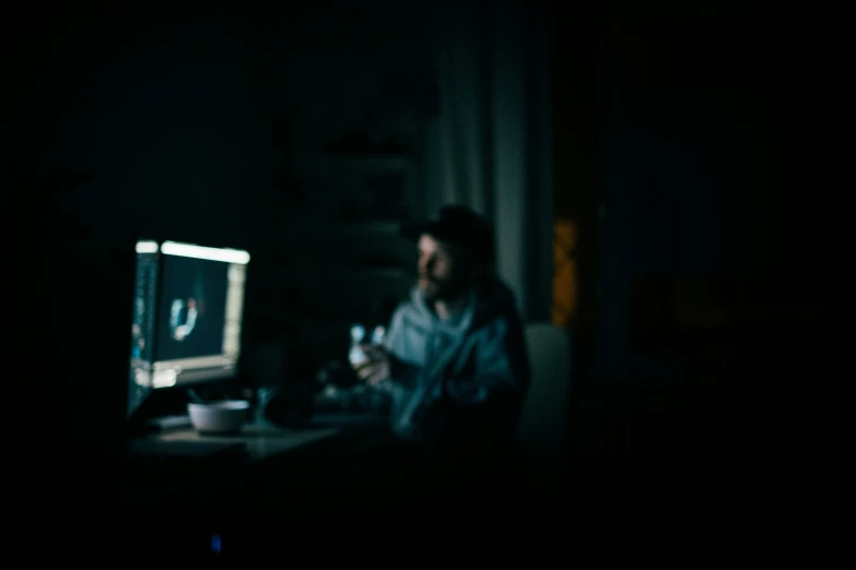 a person holding a drink while sitting in front of a television