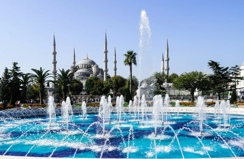 a large blue water fountain with many fountains in it