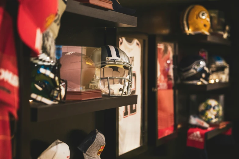 various helmets are arranged on shelves with scarfs