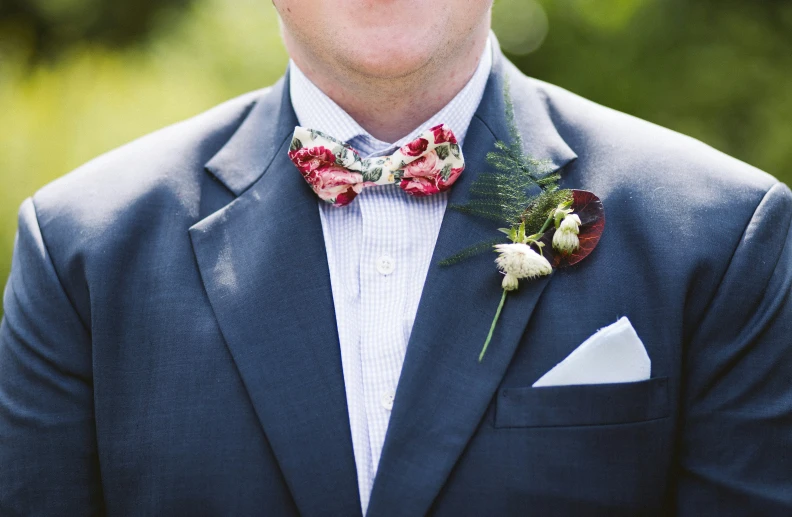 the man in a blue suit has a red and white bow tie