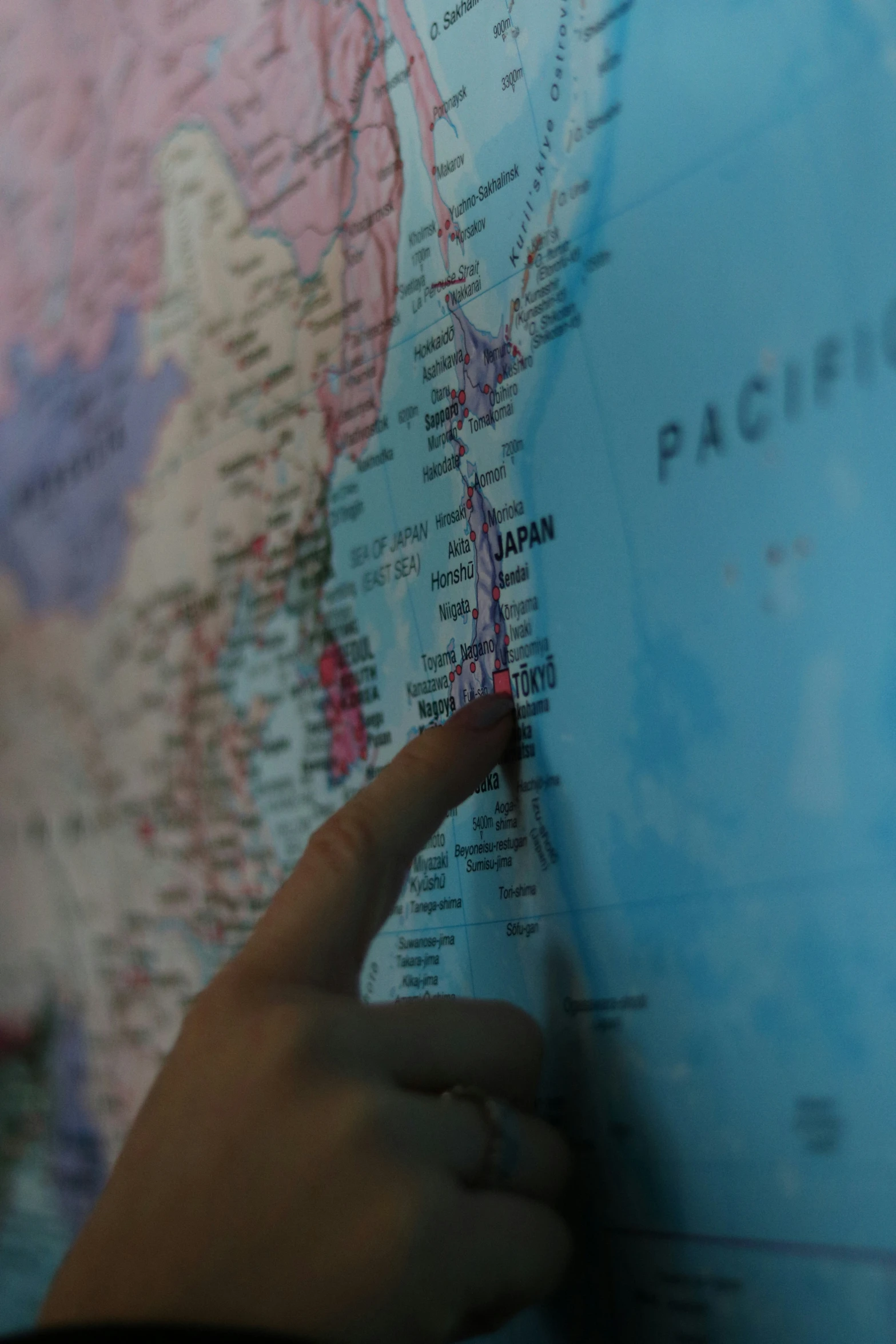 person pointing out the map on top of a large globe