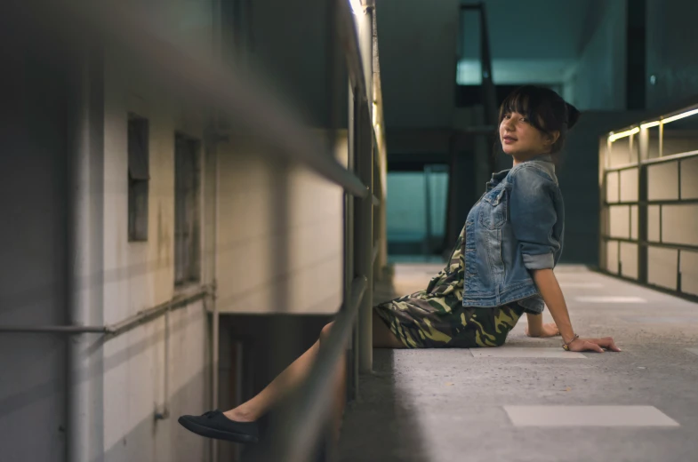 a woman sitting on a wall and staring