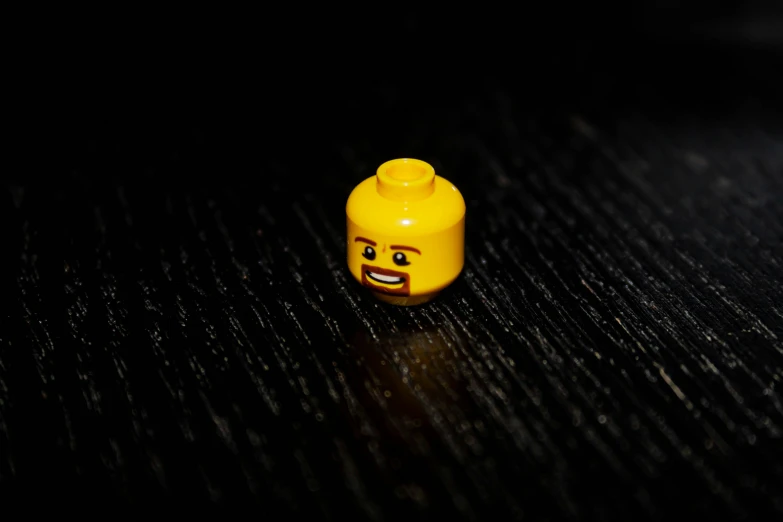 a yellow brick with a smiling face is standing on the surface