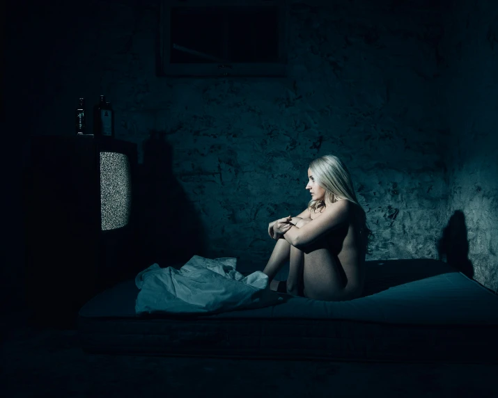 a  woman on a bed in the dark