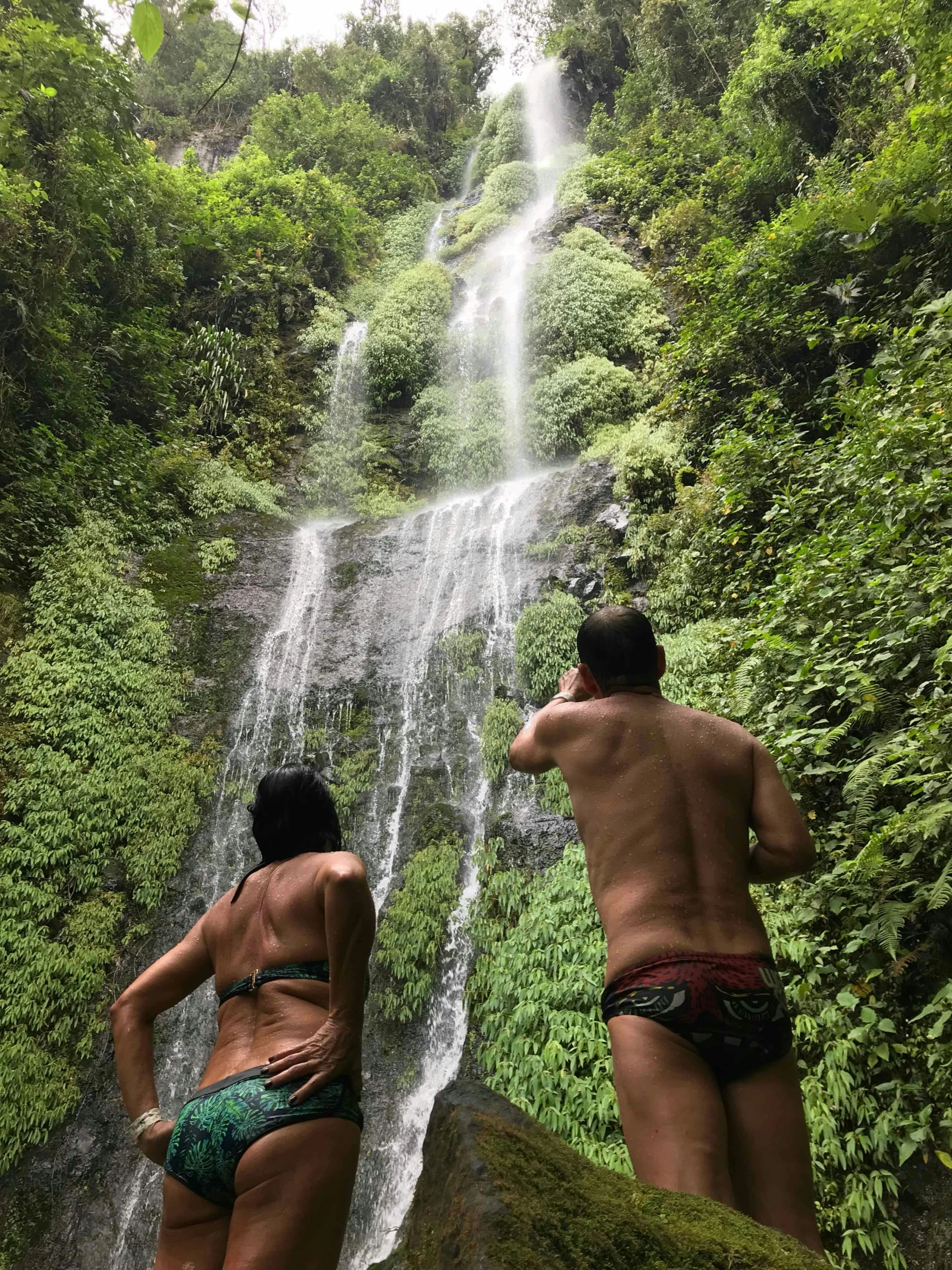 two people at a waterfall with their underwear off