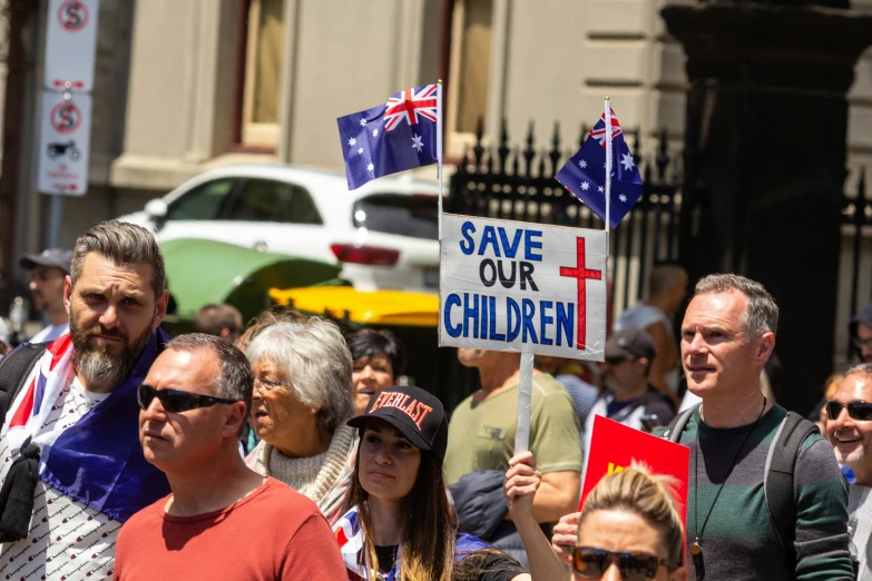 people are standing on the street holding up signs