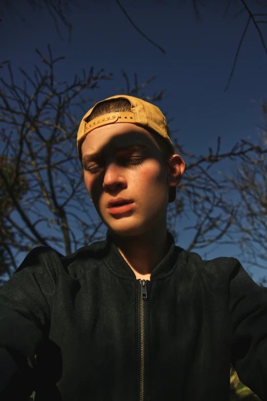 a boy in a jacket has a bald hair and wears a gold hat