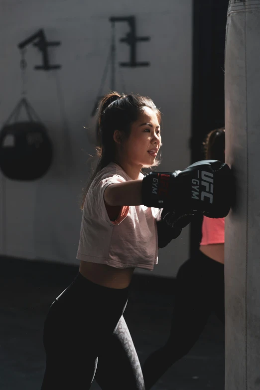 a young woman with boxing gloves on at a gym