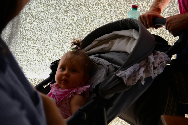 a baby girl sitting in a stroller