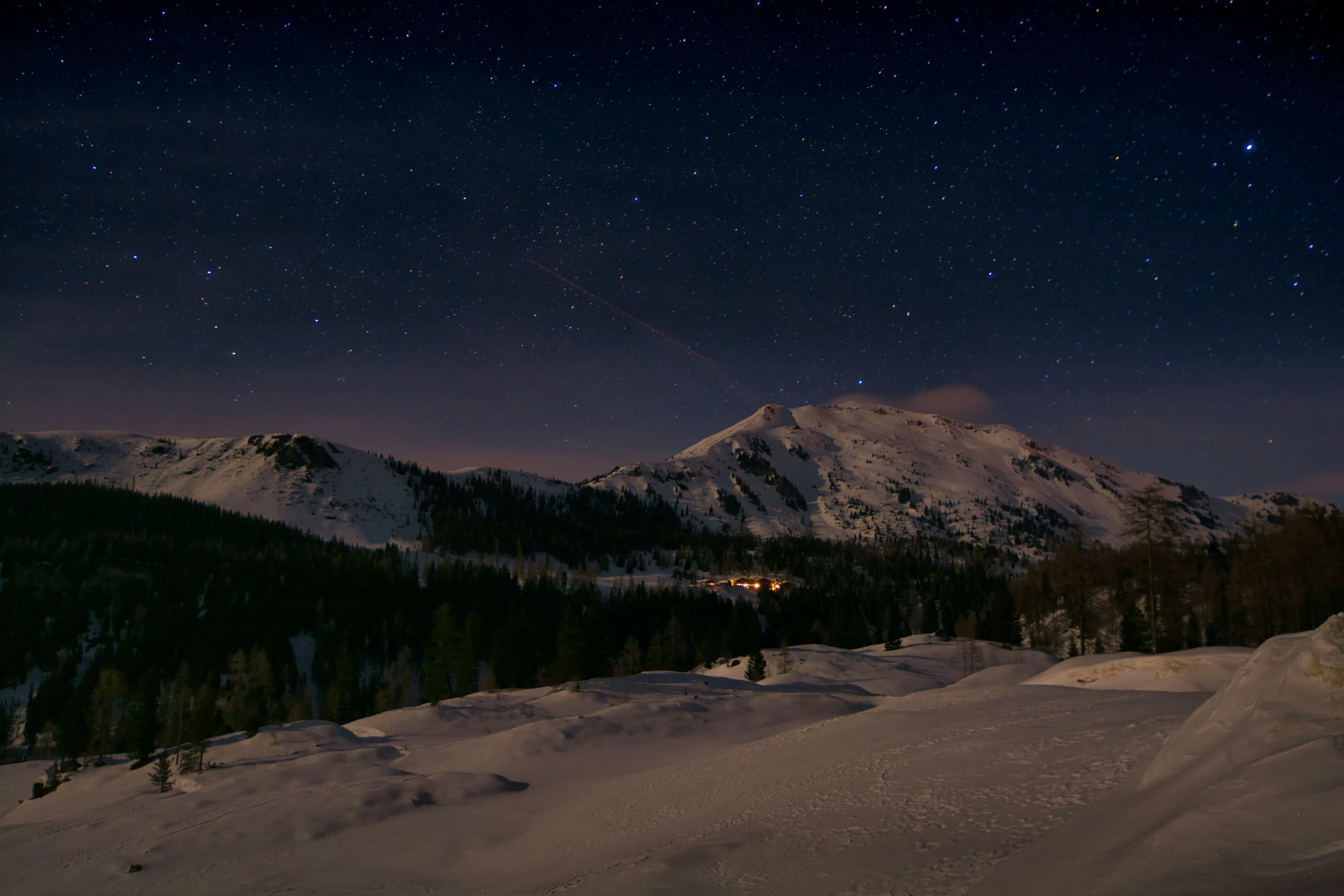 the night sky lights up the snowy landscape