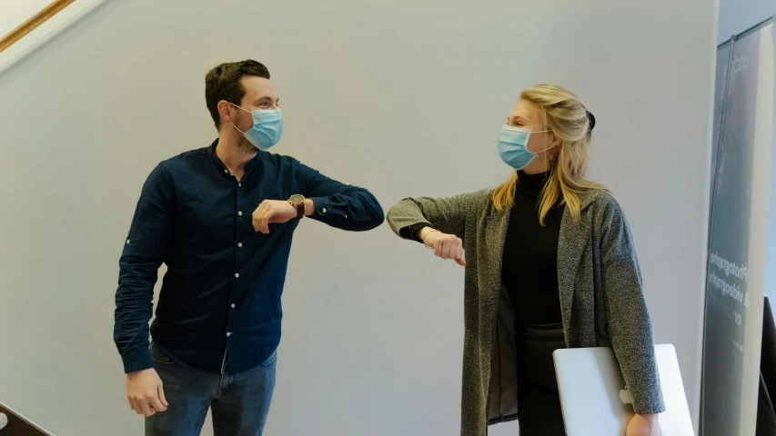 a woman shaking hands with a man in a blue shirt