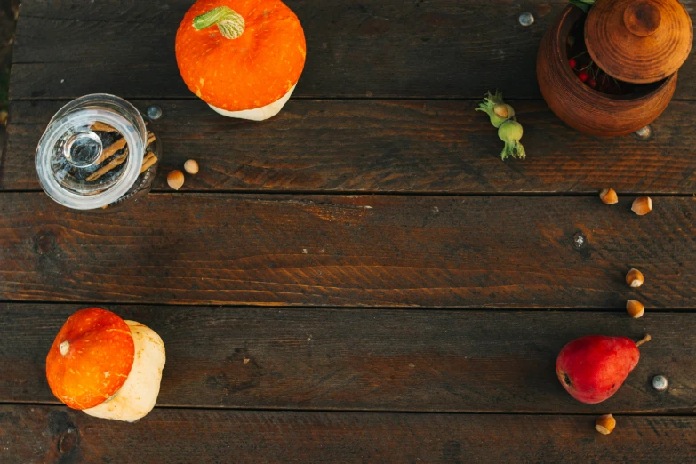 a wooden table topped with fruits and glasses