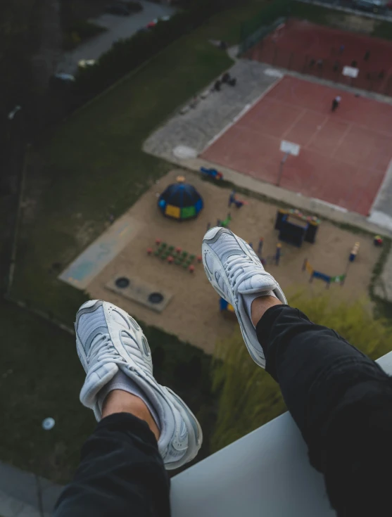 two feet with sports equipment visible from a building