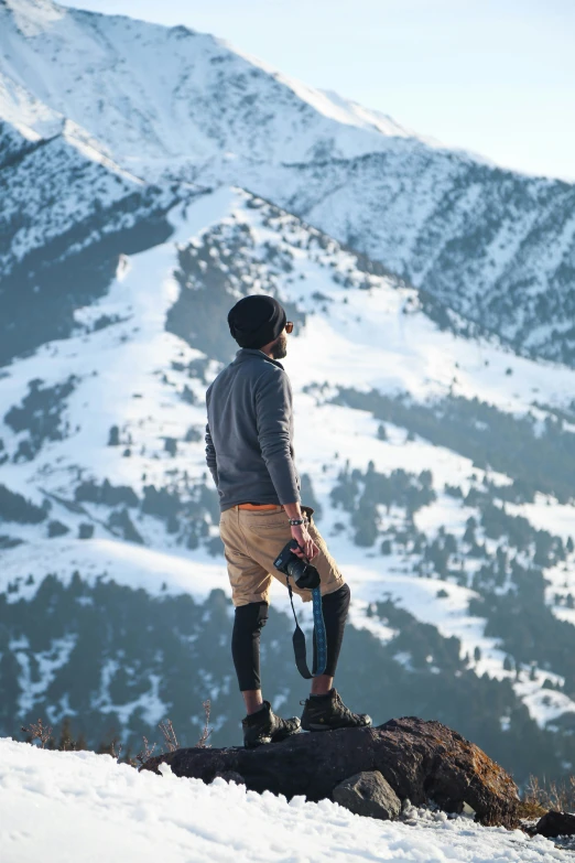 a man standing on top of a snow covered hillside