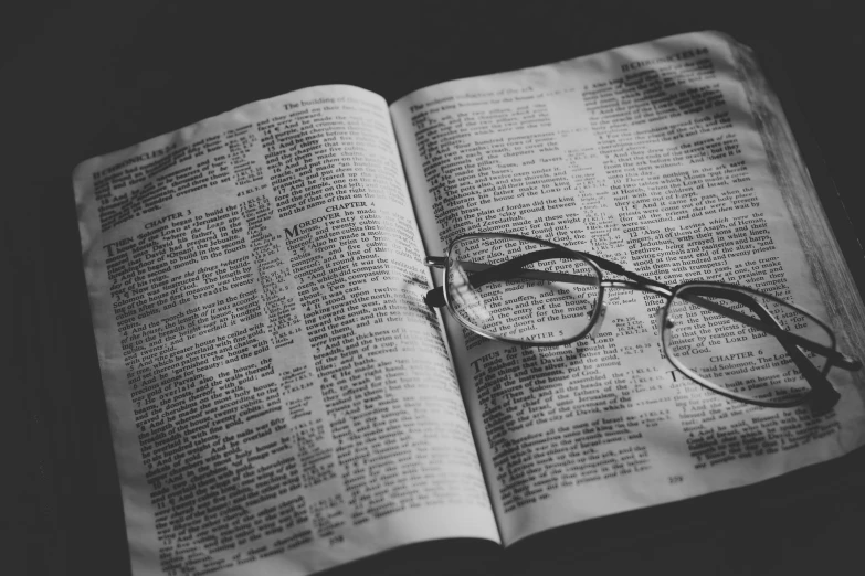 reading glasses resting on an open bible