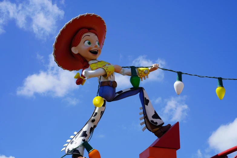 a giant character statue hanging from a string outside