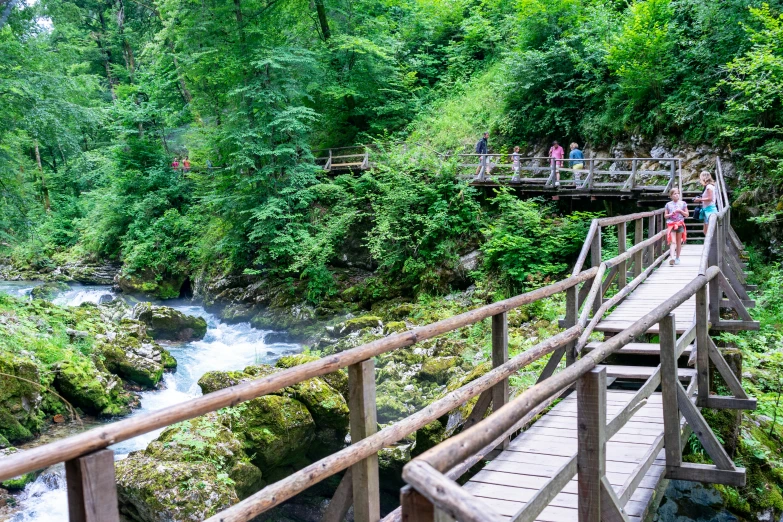 a wooden walkway next to a mountain river