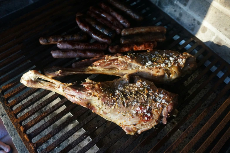 two different types of meat are grilling on the grill