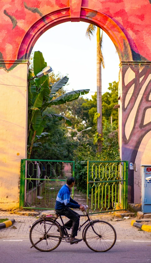 a person riding a bike past some archways