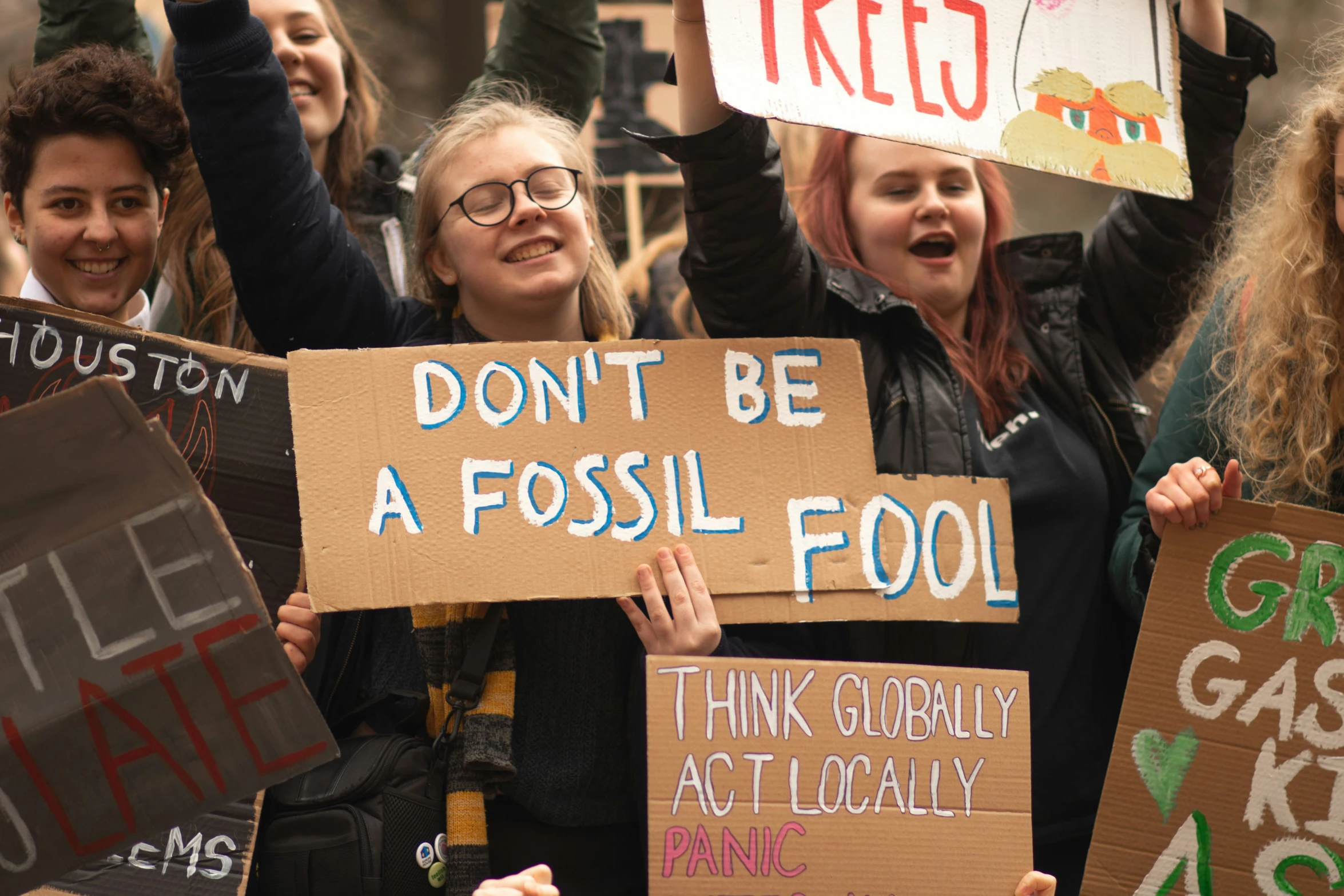 several people standing together with signs and holding up their hands