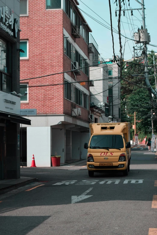 a yellow truck driving down the middle of an empty street