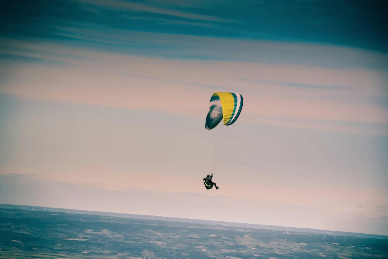 a person para sailing on the ocean against a blue sky