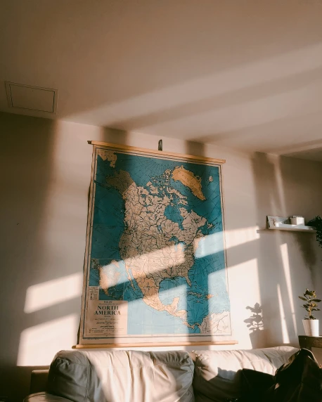a couch sitting underneath a large map on a wall
