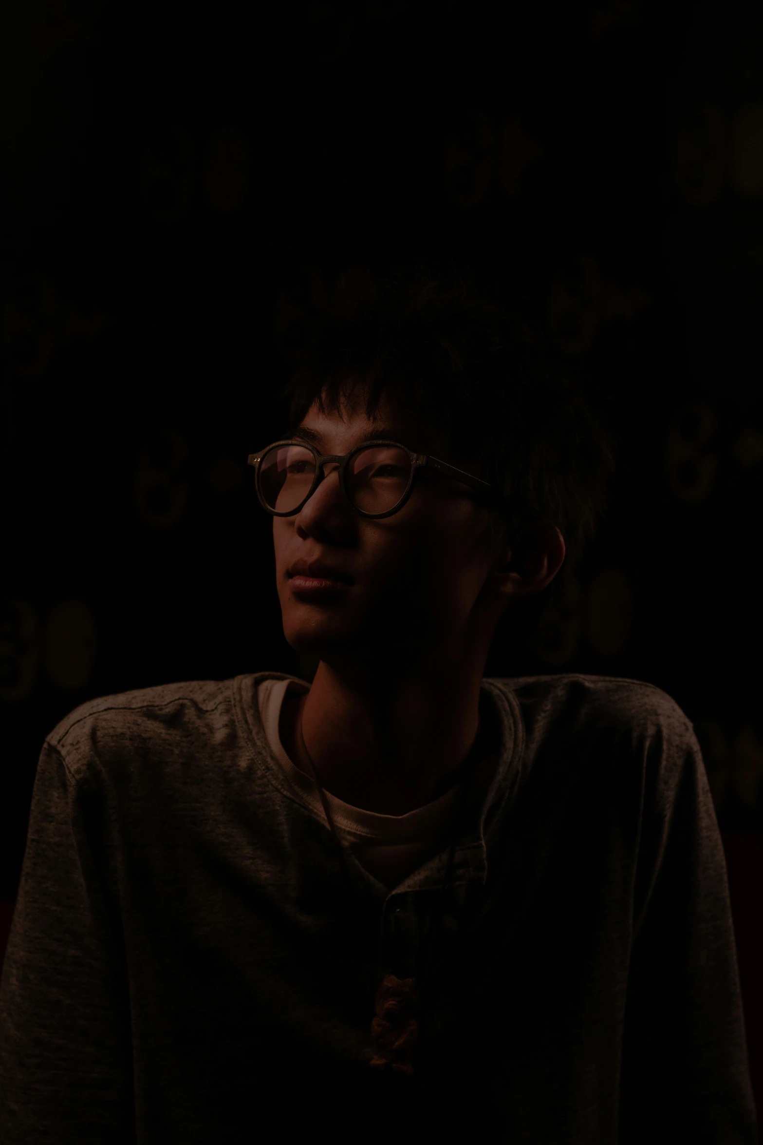 a person wearing glasses in a dark room