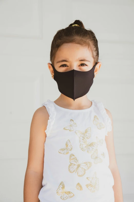 little girl wearing a black mask while wearing the black face mask