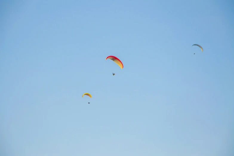 several paragliders are flying high in the sky