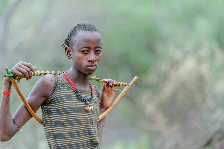 a young woman with long hair and jewelry standing on a dirt ground